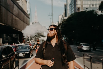 戴太阳镜的男子白天抽大麻